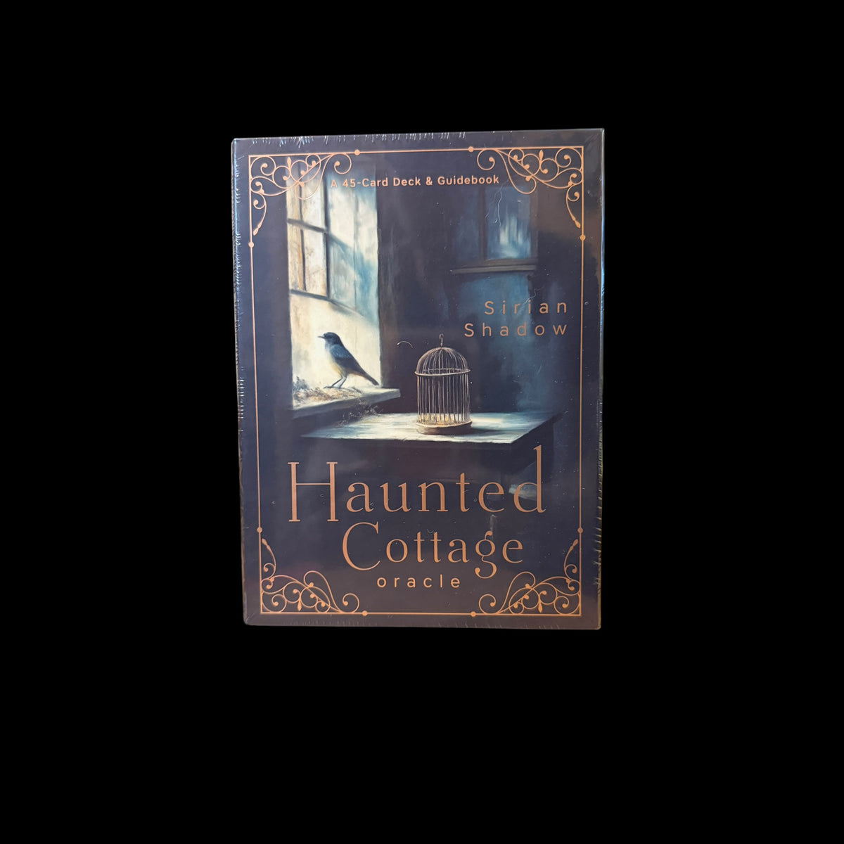Haunted Cottage Oracle deck box featuring a bird on a windowsill with a golden birdcage